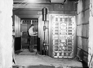 Man working on a large bank vault area circa 1934.