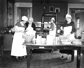 Women working in kitchen circa 1934.