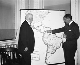 R. Walton Moore, Assistant Secretary of State, left, and Juan T. Trippe, President of Pan-American Airways, studying International routes for airplanes circa 10/31/1935.