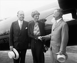 Amelia Earhart shaking hands, center circa 1932.