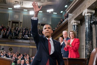 President Barack Obama waves to the First Lady and guests seated in the gallery of the House Chamber at the U.S. Capitol in Washington, D.C., Sept. 9, 2009. IN the background are Vice President Joe Bi...