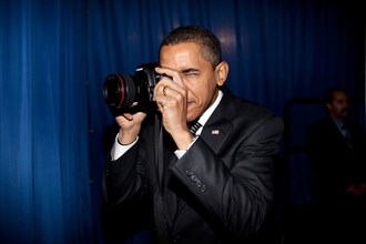President Barack Obama takes aim with a photographer's camera backstage prior to remarks about providing mortgage payment relief for responsible homeowners. Dobson High School. Mesa, Arizona 2/18/09. ...