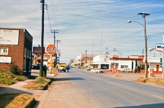 Gas stations on a street in Center Texas circa 1957-1960.