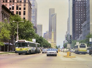 Cars and buses in busy downtown Chicago traffic circa 1985 .