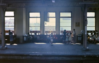 Typical scene in a train station in Japan (little boy reading a book)  circa 1976 .