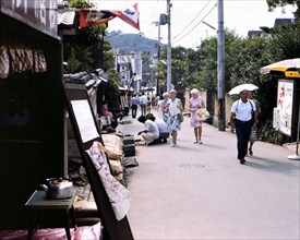 Shops on a small street with American tourists in Kyoto Japan circa 1976.