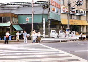 Lady street cleaners waiting at traffic crossing in Kanazawa Japan circa 1976.