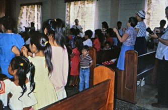 (R) Latin America / Honduras circa 1987 - people worshipping in a small church in Honduras (small village church) .
