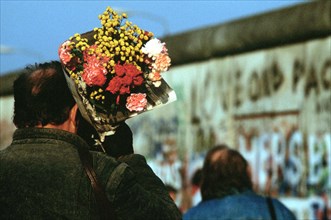 A visitor brings flowers to place at the newly created opening in the Berlin Wall at Potsdamer Platz..