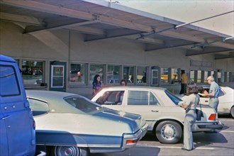 (R) New York 1975 - Cars parked at the Canada Customs station, travlers .