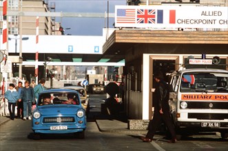 East Germans drive their vehicles through Checkpoint Charlie as they take advantage of relaxed travel restrictions to visit West Germany..