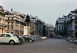 Parked cars and double decker bus on streets of London circa 1970-1974.