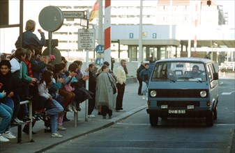 West German children applaud as an East German man drives through Checkpoint Charlie and takes advantage of relaxed travel restrictions to visit West Germany..