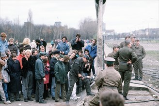 A crowd gathers on the West German side of the Berlin Wall at Potsdamer Platz to watch as the structure is dismantled..