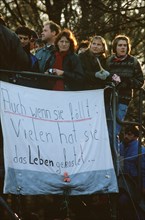 West German citizens display a banner as they maintain a vigil for the demolition of the Berlin Wall near the Brandenburg Gate.  A portion of the Wall has already been demolished at Potsdamer Platz..