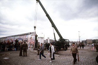 East Berliners cross over to the West as a crane is used to dismantle the Berlin Wall at Potsdamer Platz..
