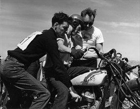 Three Young Men Prepare for Motorcycle Hill Climb