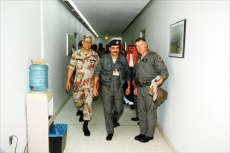 DESERT SHIELD - Colin Powell in fatigues in Saudi Arabia walks with a Saudi Arabian pilot.