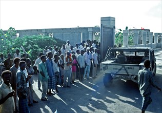 1992 - Somalis watch as an M-998 series vehicle enters the Joint Task Force Somalia headquarters.