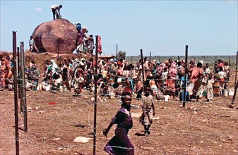 1993 - A Group of Somali refugees gathers behind barbed wire fence to get water from a well.