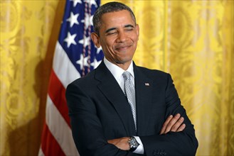 President Barack Obama smiles as first lady Michelle Obama speaks