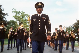 1977 - A drum major leads a US Army band while marching in formation.