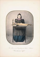 A woman sitting by the table With a langleik in front of her