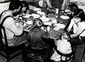 Family eating meal of hominy grits