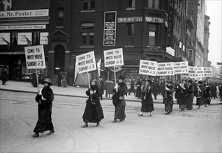 Woman suffragettes marching through the streets