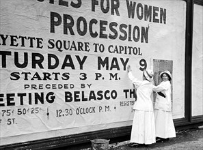 Woman suffragettes posting billboard poster