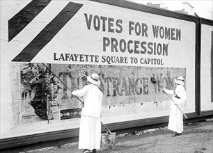 Woman suffragettes working on billboard