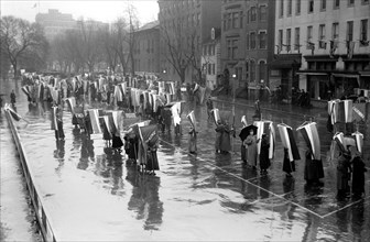 Woman suffragettes marching in the rain