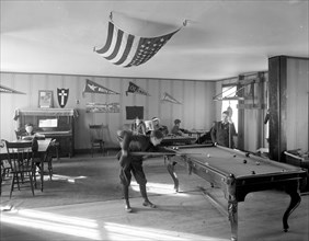 Early 1900s men playing billards in pool room