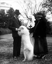President Calvin Coolidge with dog outdoors with two women