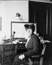 Woman sitting at desk with old telephone