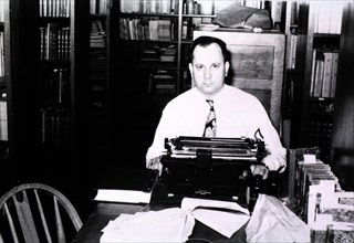 Man sitting in front of a typewriter