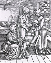Three midwives attending to a pregnant woman