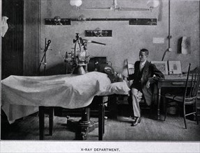 African American man is on a table covered with a sheet lying beneath an x-ray machine