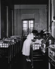 An African American nurse is at the bedside of a newborn
