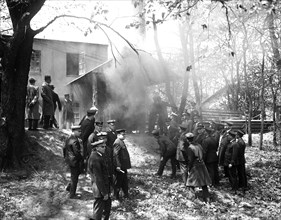 Men in uniform outside a house on fire