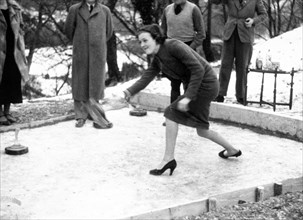 Woman playing some type of curling game outdoors