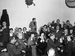 German men and women raising beer glasses Octoberfest 1936.