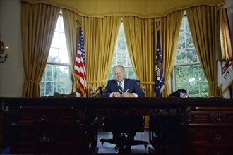 Gerald Ford signing presidential pardon of Nixon.