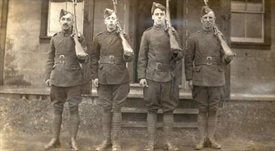 Four airmen holding rifles over their left shoulders
