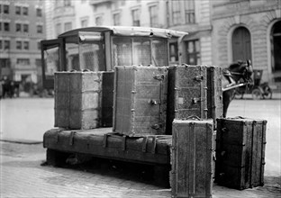 Packing trunks sitting on the side of a city street ca. 1909