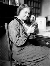 Early 1900s woman sitting and talking on the telephone ca. 1913