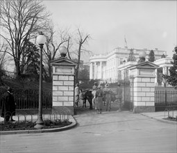 People with pack animals at the gate of the White House ca. 1910