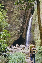 Tourists on a hiking trail visiting Sacred Falls in Oahu Hawaii