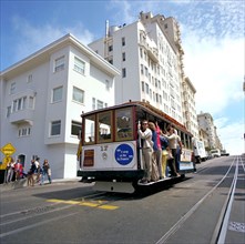 Tourists riding the famous San Francisco cable car