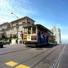 Tourists riding the famous San Francisco cable car
